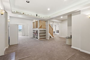 Basement Rec Room with under stair shelving and view of bonus room