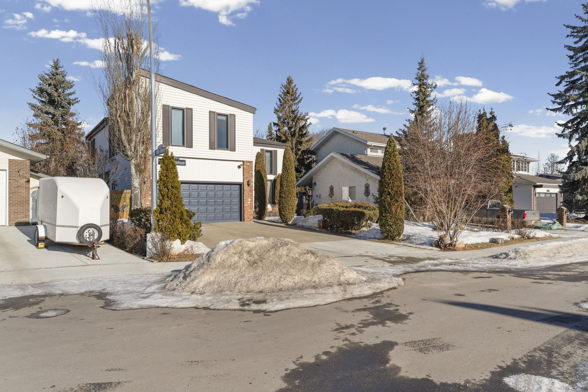 Street-side view of the home, driveway and snow-covered front planting beds.