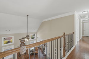 Upstairs hallway features hardwood floors leading to the three bedrooms upstairs
