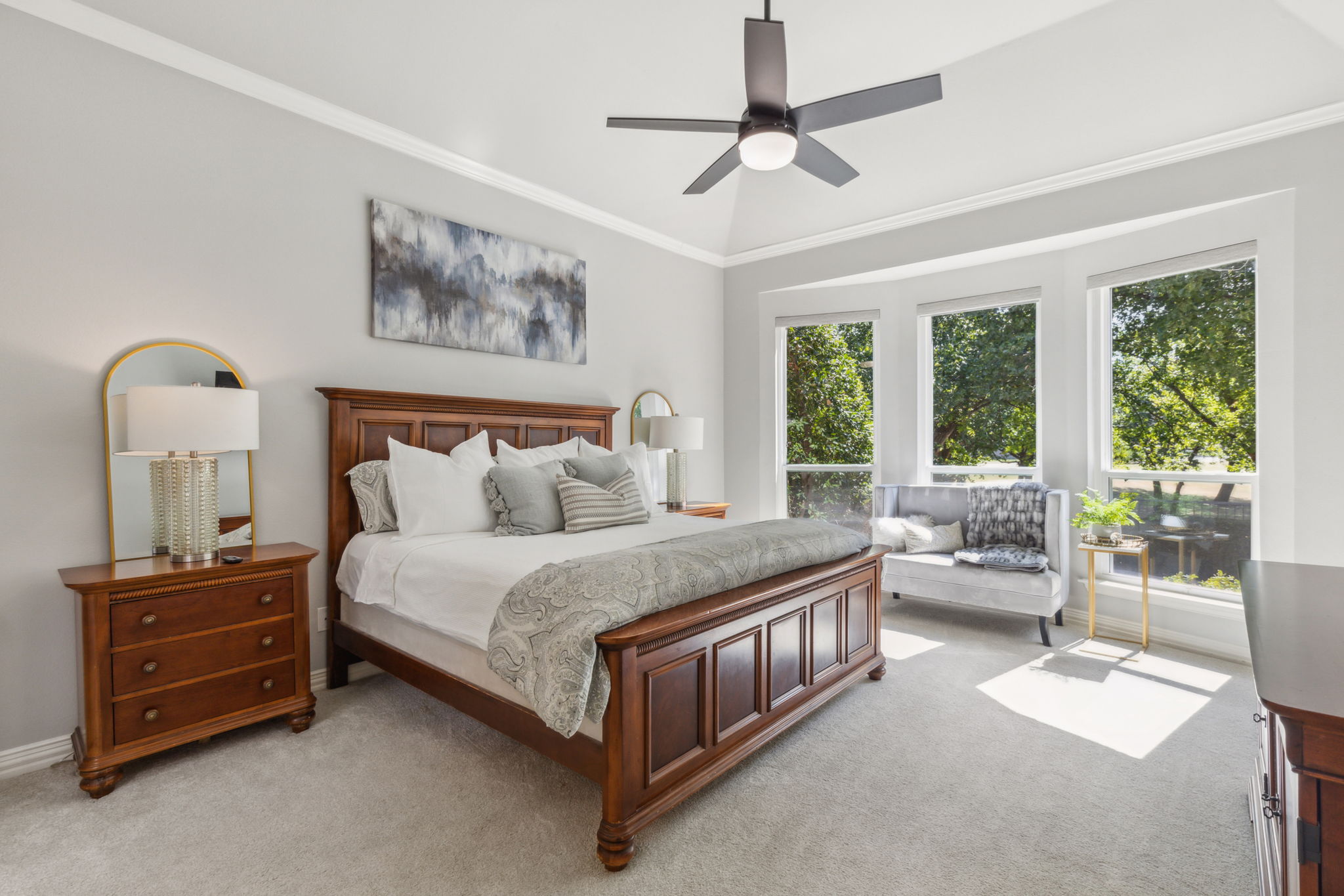 The primary bedroom has vaulted ceilings, crown molding, and a bay window with a cozy sitting area to enjoy the views.