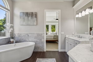 Here's another perspective of the primary bathroom, showcasing the freestanding tub with a view into the primary bedroom.