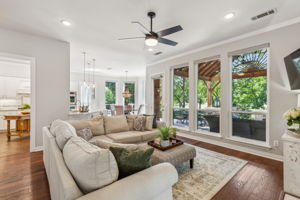 Panoramic windows are the focal point of the family room and breakfast area, enhanced by charming engineered wood floors and a new ceiling fan that create a warm ambiance. NOTE: All-new shades installed in 2020 provide easy access to these stunning views!