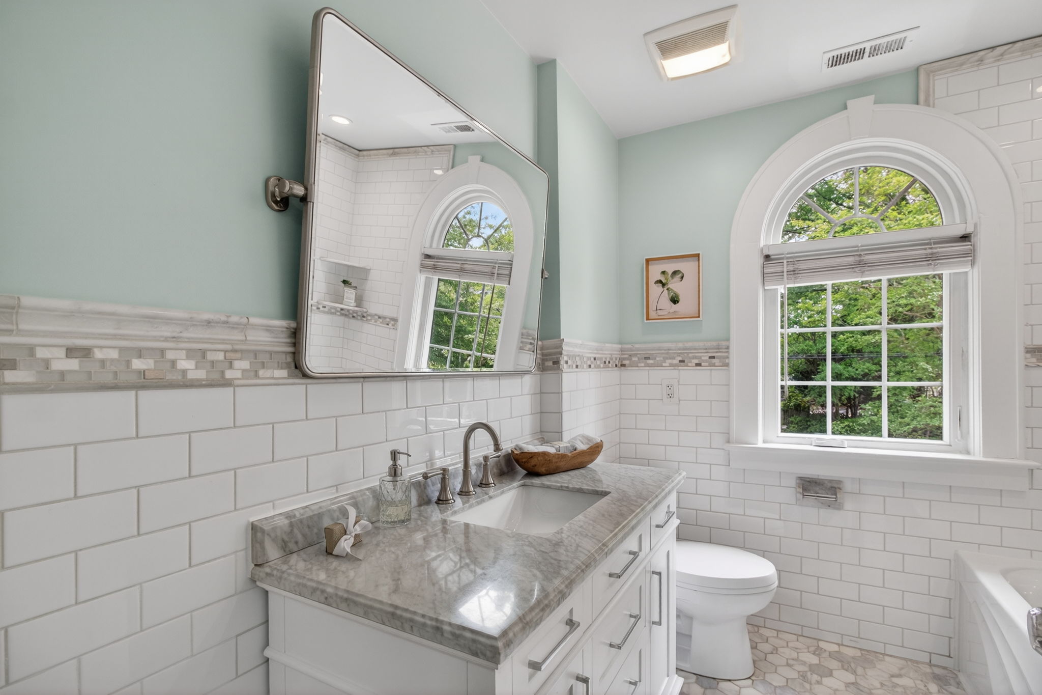 Hall bathroom with new vanity, new mirror, gorgeous tile and fantastic detail in the rounded window.