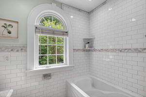 Hall bathroom with new vanity, new mirror, gorgeous tile and fantastic detail in the rounded window