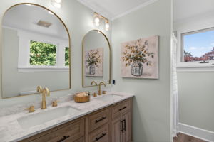 Primary bathroom with dual vanities, new LVP flooring and walk-in-shower
