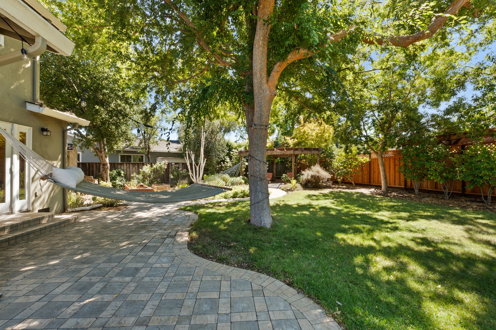 A delightful pathway and serene backyard featuring a soothing cradle for relaxation.