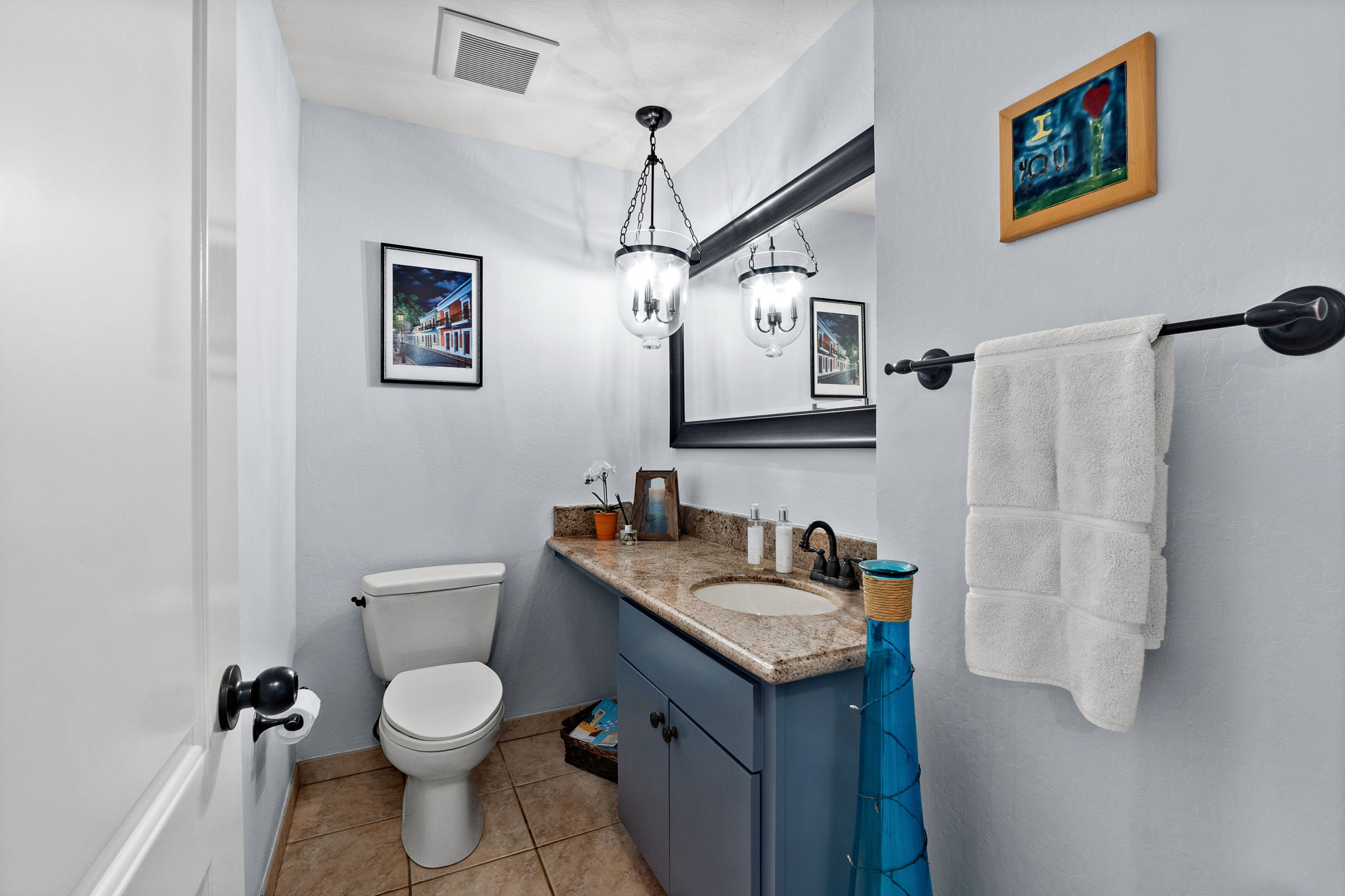 An upscale washroom with a toilet, a decorative basin, and a contemporary mirror.