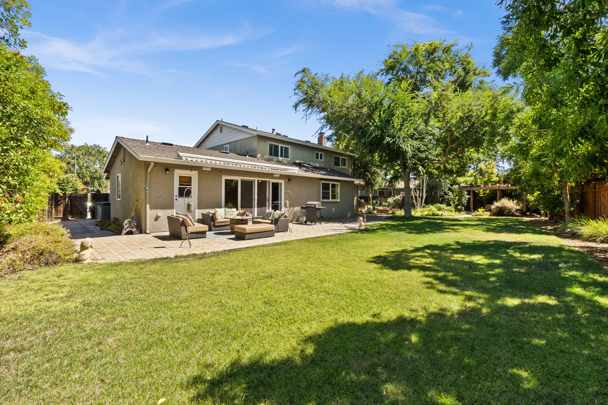 A serene backyard with a lush lawn and an inviting patio.