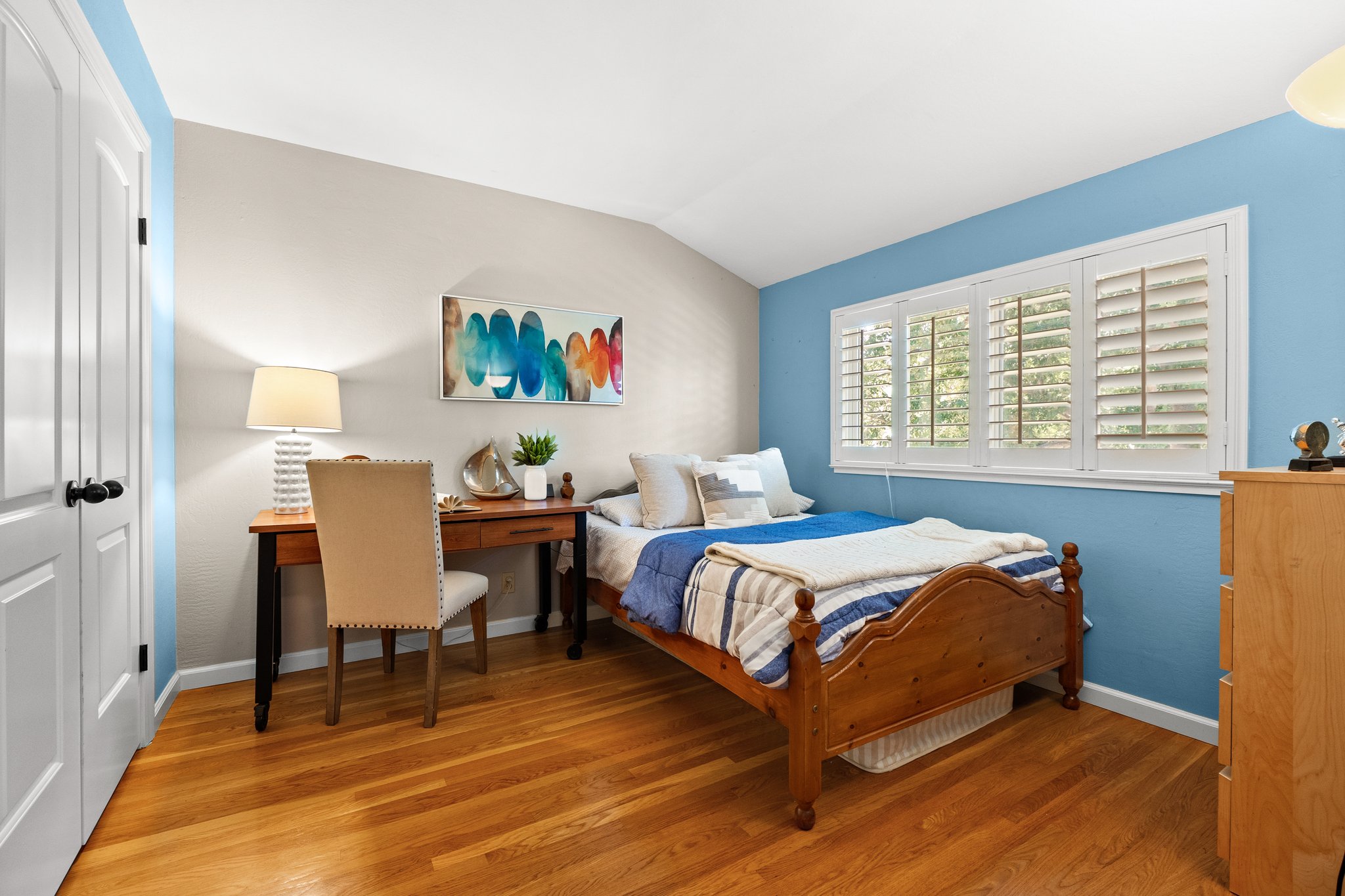A stylishly arranged bedroom with a bed and a modern desk.