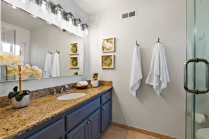 A bathroom exuding pure luxury with its lavish sink and an intricately framed, full-length mirror.