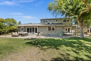 An exquisite outdoor haven, perfectly suited for hosting special events and gatherings, adorned with an expansive, meticulously landscaped backyard.