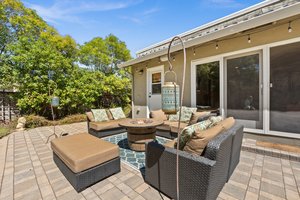 An upscale patio graced by an inviting fire pit and elegant chairs.
