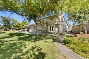 A distinguished dwelling with a sprawling and beautifully landscaped backyard.