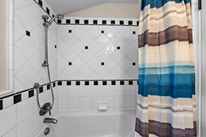 A bathroom adorned with a shower curtain and a bathtub.