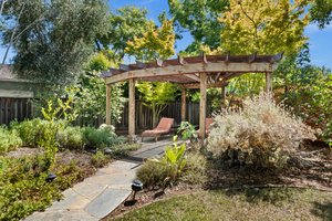A meticulously designed outdoor sanctuary complete with a sophisticated gazebo and an opulent bench.