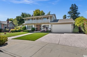 An exquisite estate, set amidst an expansive, vibrant lawn and a regal, cobblestone driveway.