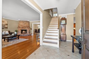 Living room with a staircase leading to second floor with four bedrooms, including a Private Master Suite.