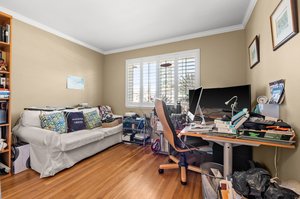 A versatile office room equipped with a desk, computer, and a comfortable sofa.
