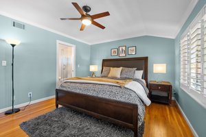 An exquisitely curated Master bedroom, featuring a lavish bed and a ceiling fan, embodying year-round comfort and timeless elegance.