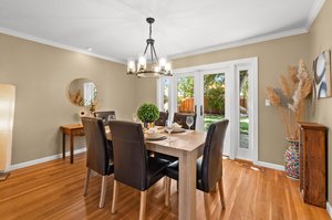 A sophisticated dining area adorned with a wooden table and chairs.