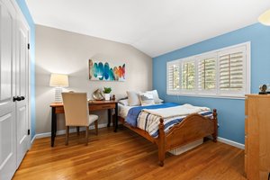 A stylishly arranged bedroom with a bed and a modern desk.