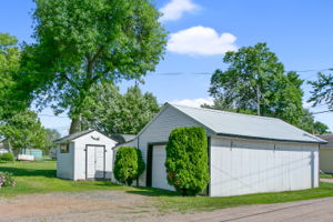 Deep single stall garage with metal roof, storage shed and 20' shelter logic