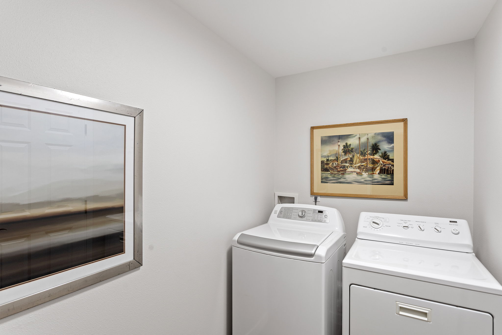 Bright and efficient laundry space with full-size washer and dryer.