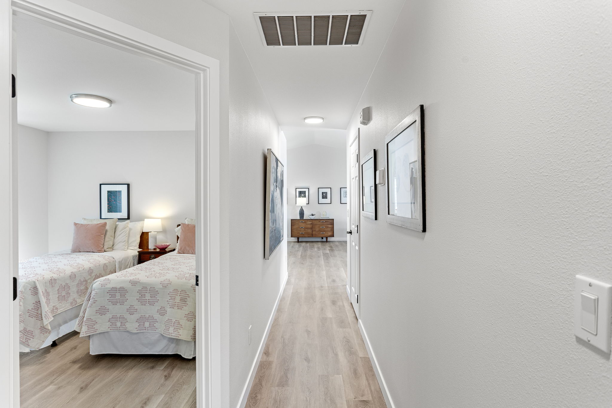 Bright hallway connects the bedrooms to the main living space, with a peek into the charming secondary bedroom.
