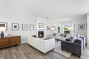Skylit living room with vaulted ceilings, gas fireplace, and fresh white trim for a bright, airy feel.