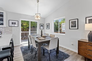 Dining area with vaulted ceiling and modern pendant lighting, overlooking the backyard.
