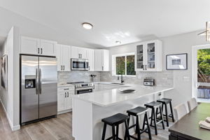 Fully remodeled kitchen with sleek quartz counters, stainless appliances, and custom cabinetry.