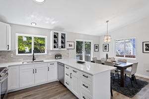 Glass-front cabinets and subway tile backsplash bring style and function to the kitchen. Over-the-sink window frames the view overlooking the lush, private backyard.