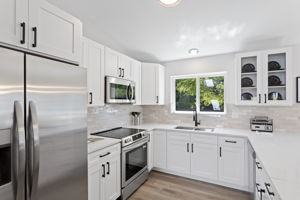 Brand-new stainless appliances, an undermount sink, and expansive counters elevate both form and function.