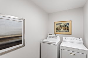 Bright and efficient laundry space with full-size washer and dryer.