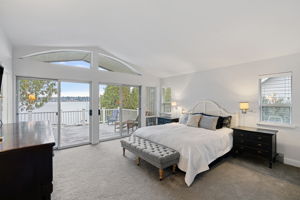 Wake up to breathtaking lake views in this primary bedroom.