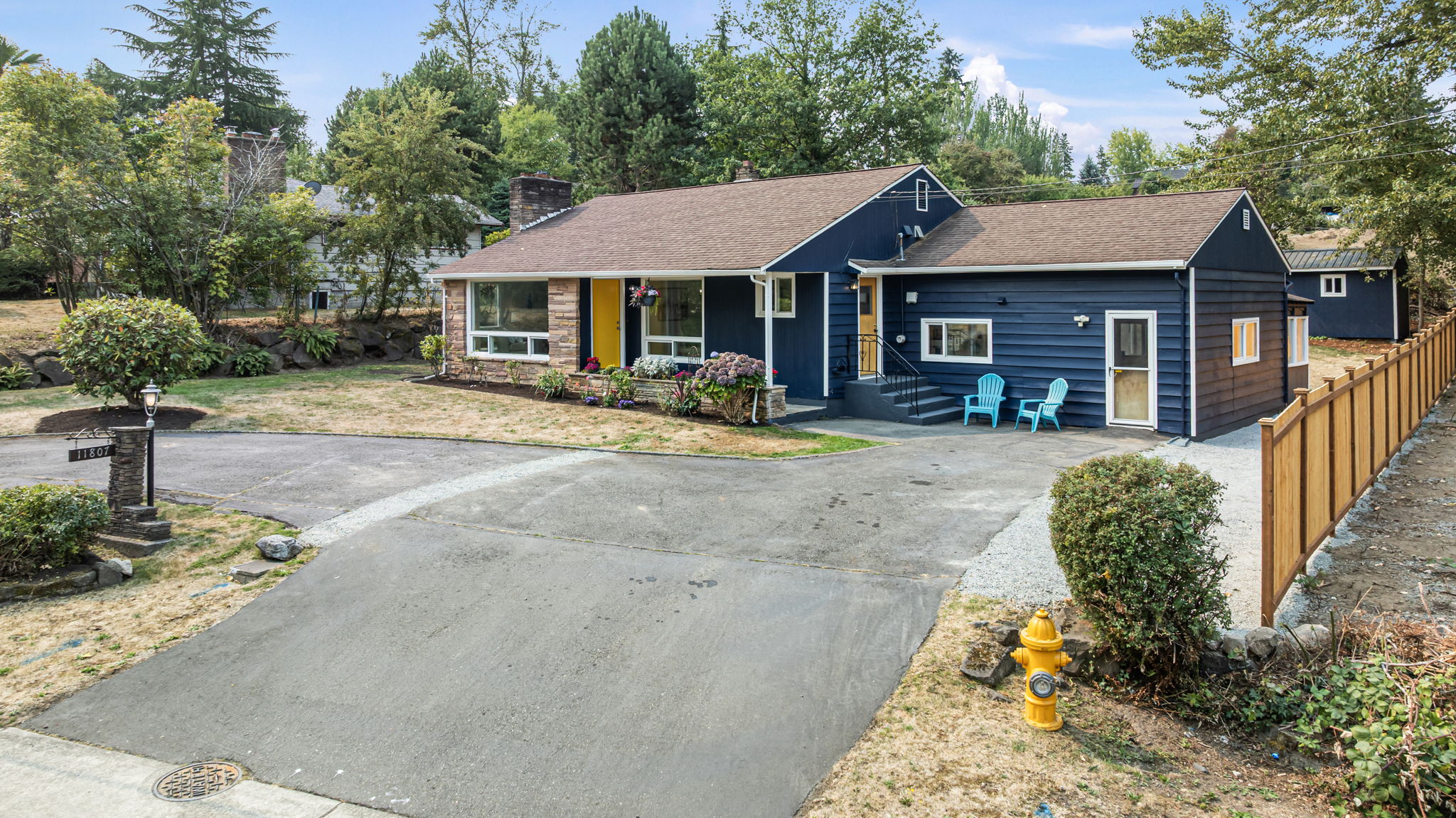 Fresh exterior paint, Goldfinch-yellow door, and side-entry seating add personality and welcome.