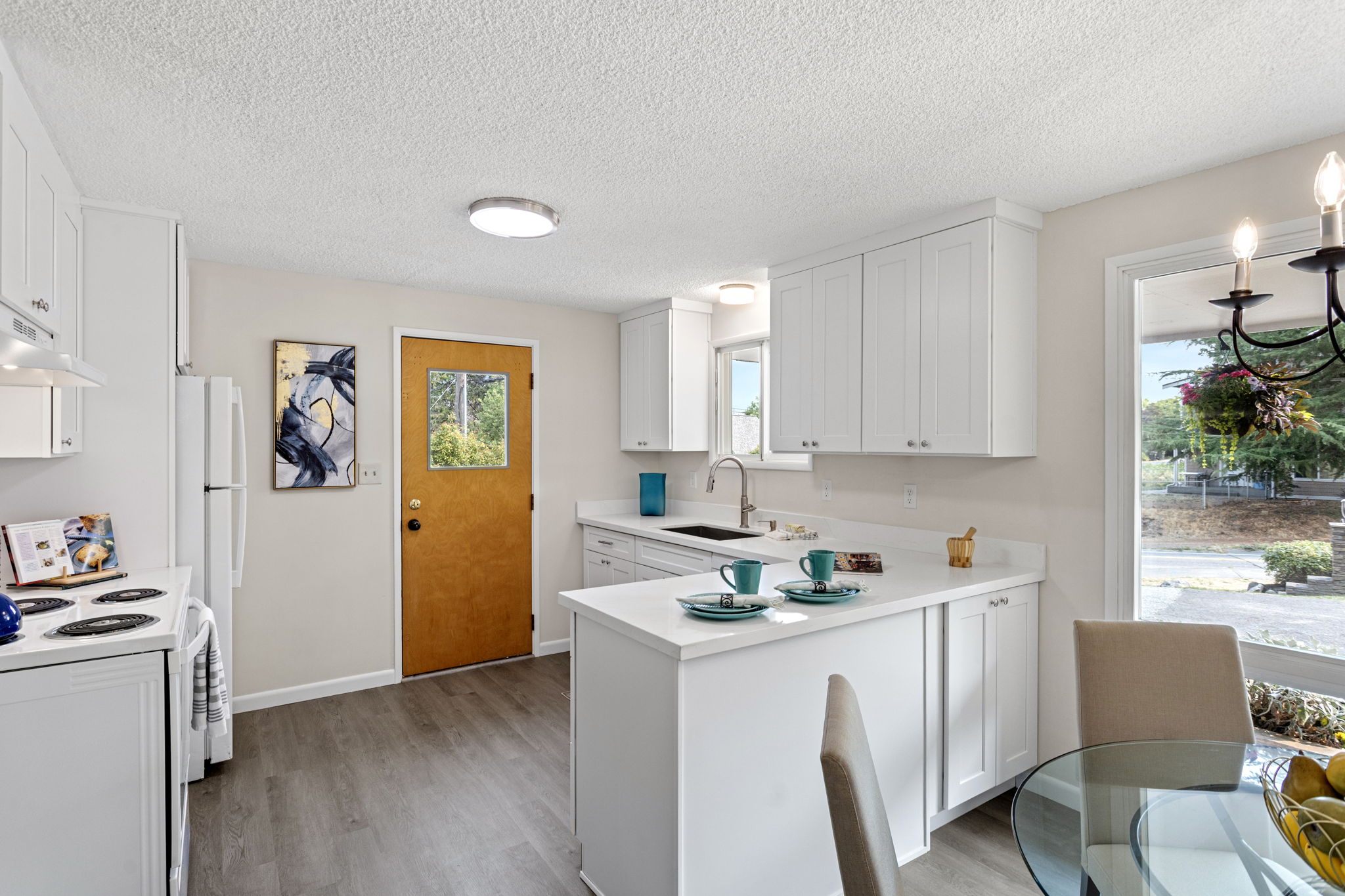 Beautifully reimagined kitchen with quartz countertops, soft-close cabinetry, and a peninsula for added storage and bar seating.