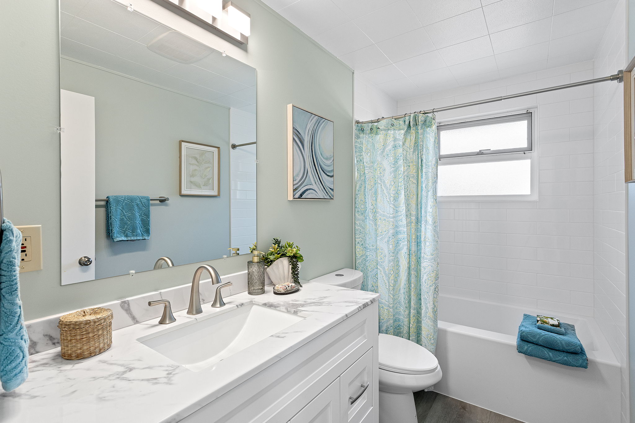 Fully updated full bath with new vanity, fixtures, LVP flooring, and ceiling-height subway tile—clean, calm, and timeless.