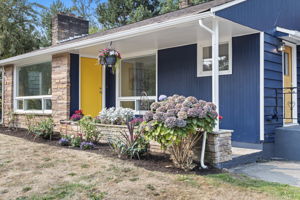 Hydrangeas, stone-faced planter beds, and layered textures brighten the entry path.