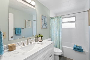 Fully updated full bath with new vanity, fixtures, LVP flooring, and ceiling-height subway tile—clean, calm, and timeless.