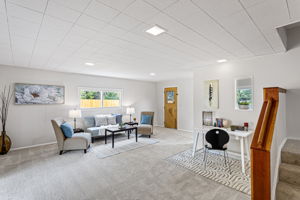 This lower flex room adds incredible versatility to the home—ideal for a second living area, media space, playroom, or creative studio. Thoughtfully set apart from the main living areas, it offers both quiet and connection. With fresh carpet underfoot, new lighting overhead, and access to the front driveway, this space adapts with ease.