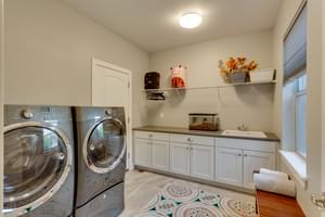 large laundry room with storage and counter space