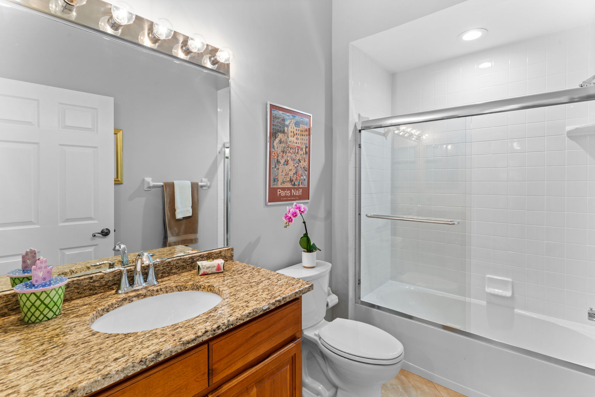 Guest bath with granite vanity and tub/shower combo.