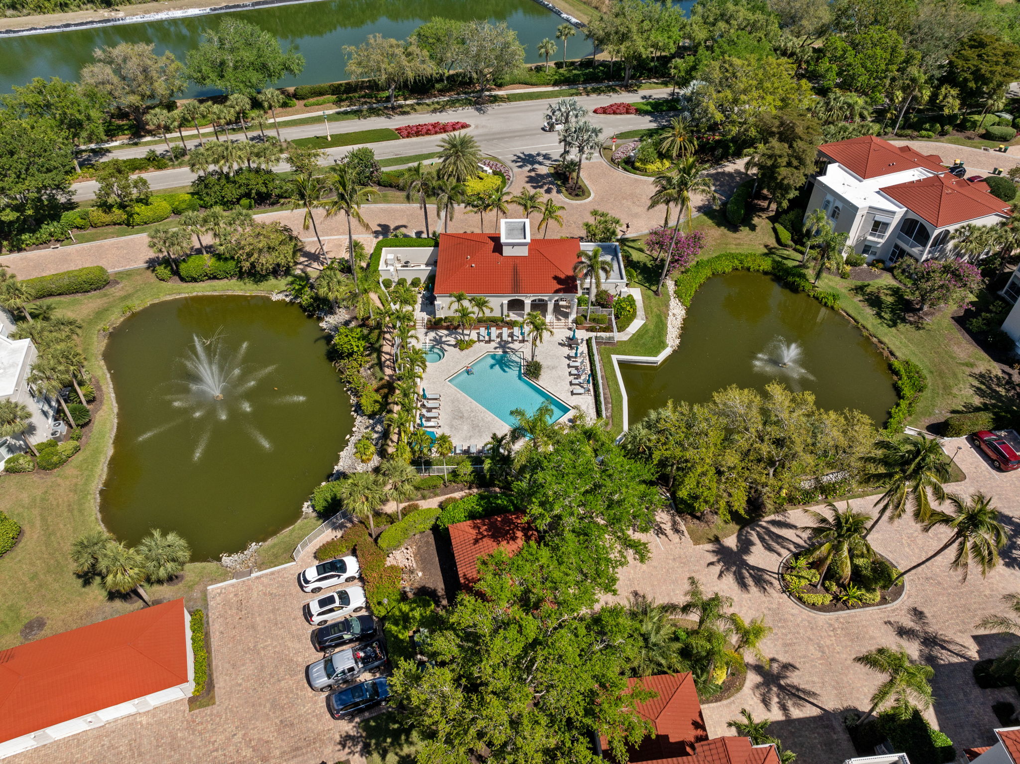 Resort-style pool and clubhouse surrounded by lakes