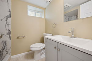 Lower level bath with shower and beautiful custom marble design tile next to the third room