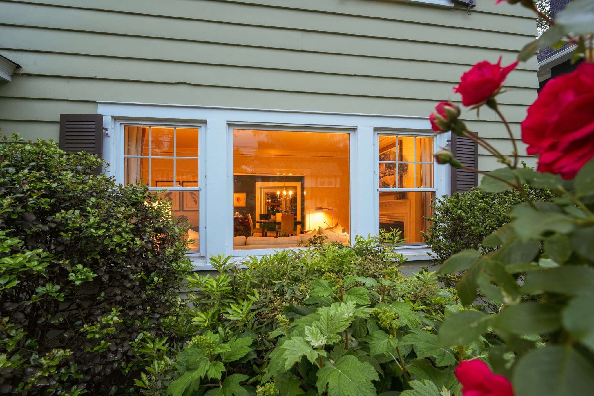 Through the roses, a glimpse of what awaits inside: warm rooms, welcoming light, and a home that has quietly nurtured generations. Some things never go out of style.