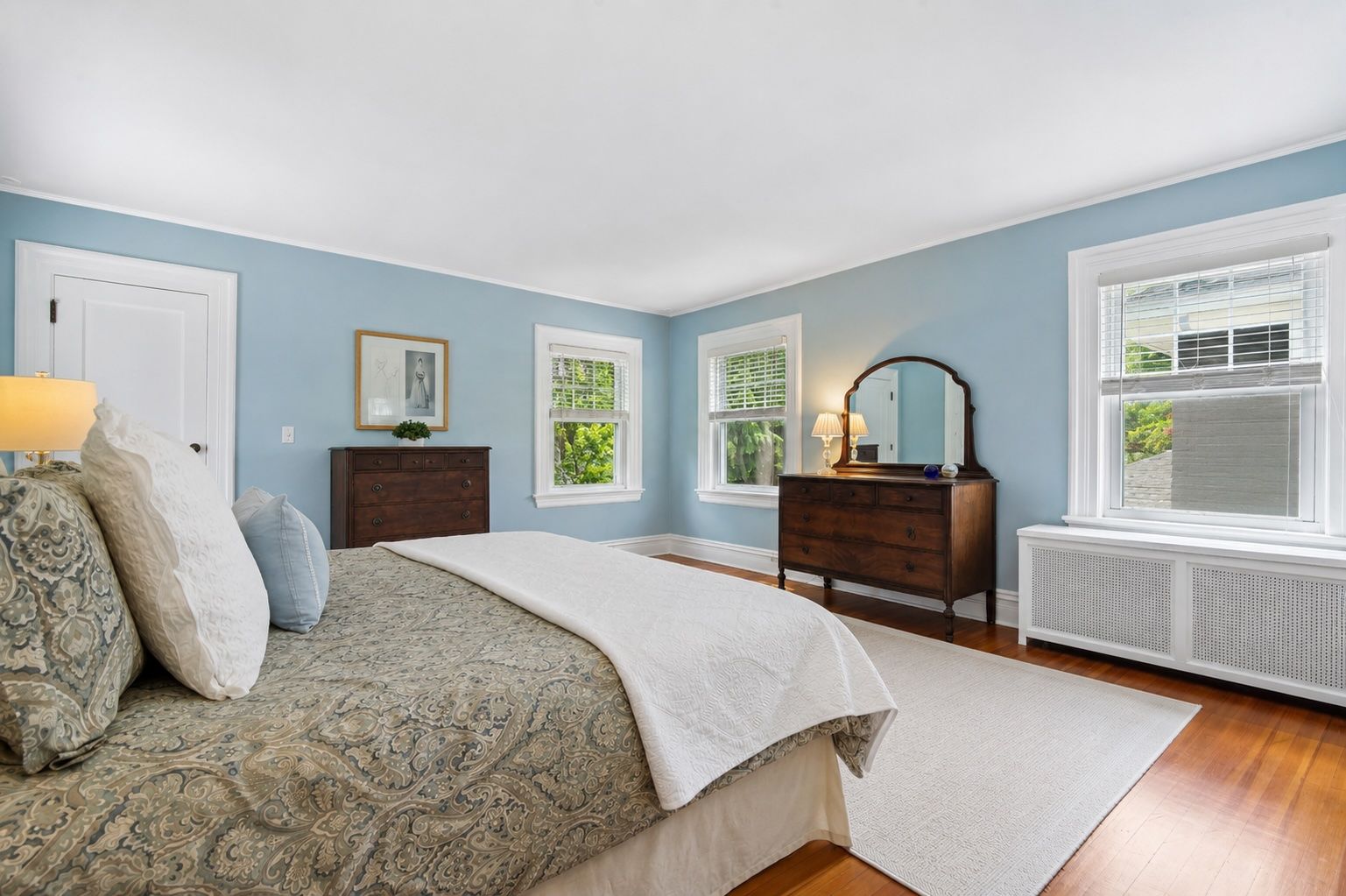 Soft natural light, peaceful views, and calming blue tones create the kind of bedroom that encourages slow mornings and early nights with a good book.