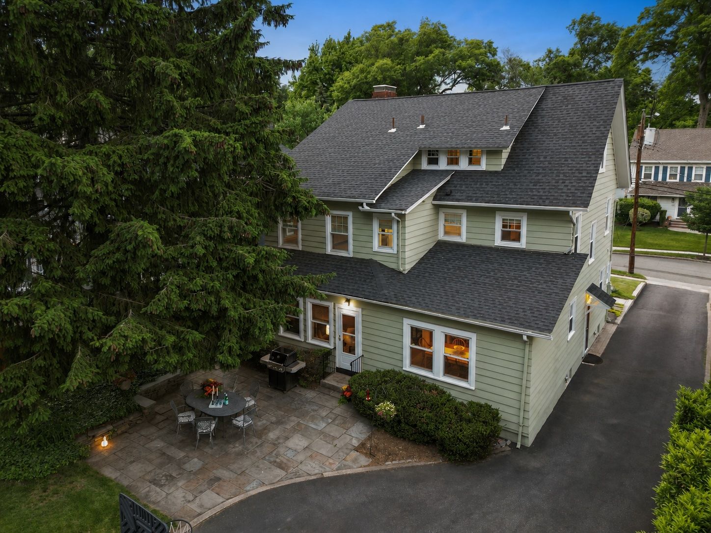 From above, you begin to appreciate just how thoughtfully this home lives. A newer roof overhead, beautifully maintained grounds below, and a private stone patio tucked beneath a beloved evergreen creating a peaceful retreat in the heart of Upper Montclair!