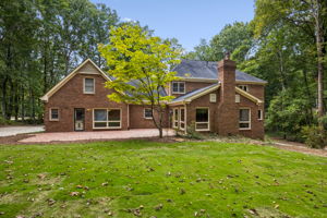 Two-story red brick exterior featuring a multi-gable roofline, exterior brick chimney, Brick patio and new sod