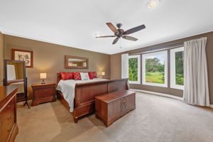 Primary Bedroom overlooks lush back yard and golf course